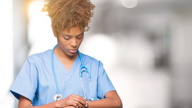 A nurse checks her watch