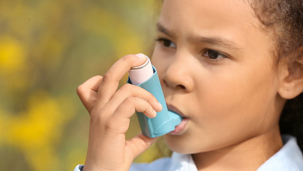 Stock photo of a girl with an asthma inhaler