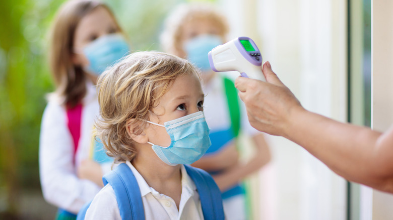 a kid getting his temperature checked