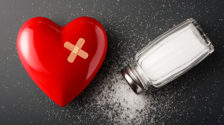 Salt shaker laying next to a heart with a bandaid over it