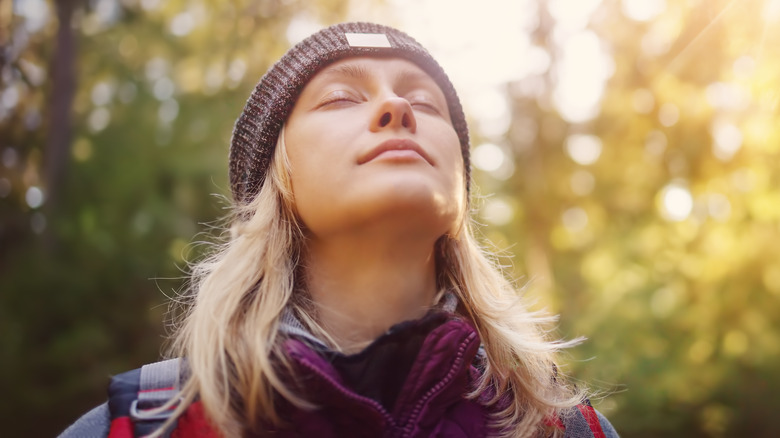 woman outside taking a deep breath