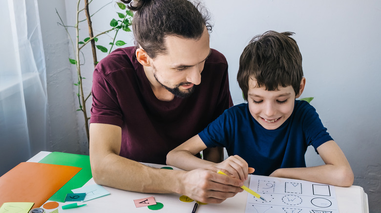 child working with his father on school work