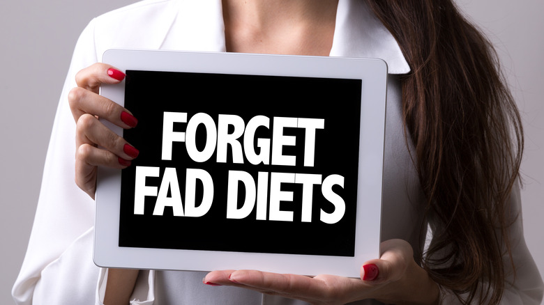 Woman holding 'forget fad diets' sign
