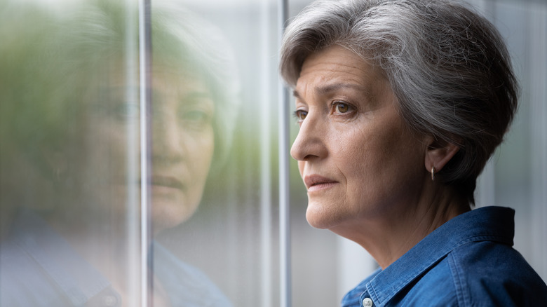 Older woman looking out window