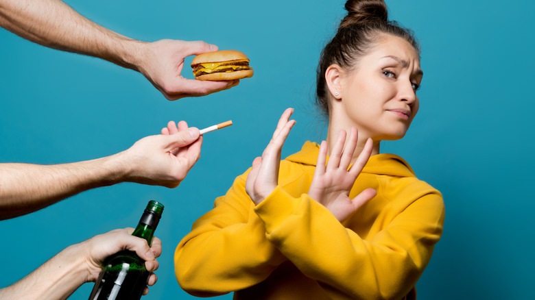 woman refusing beer cigarette burger