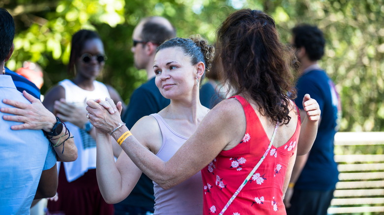 Group of partners dancing salsa outside