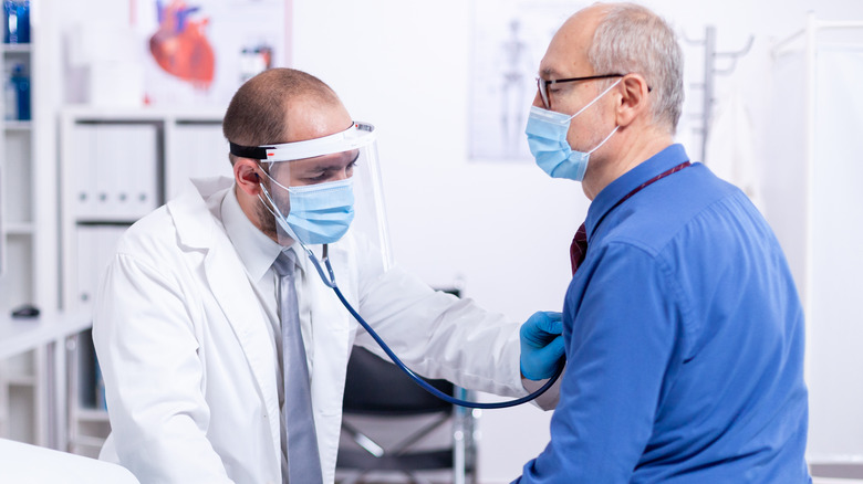 Man having lungs examined by doctor
