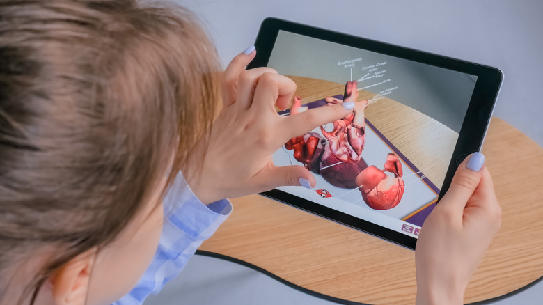 woman looking at a picture of a heart on a tablet