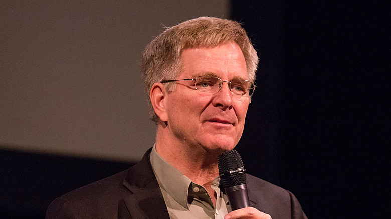 Rick Steves holding microphone