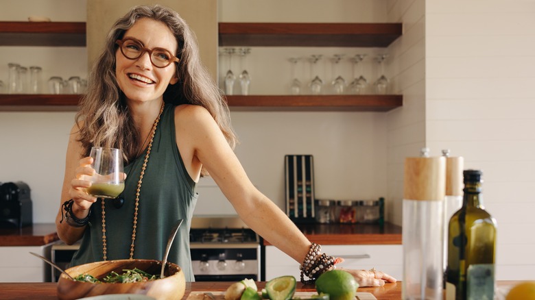 Smiling woman in kitchen preparing healthy food