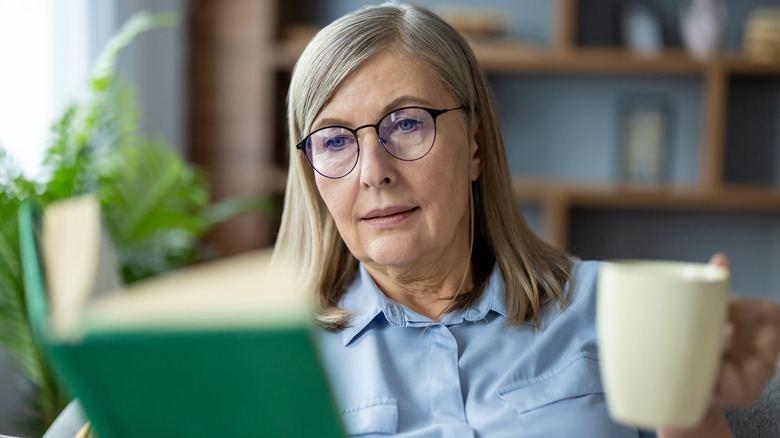 Woman wearing glasses and reading a book