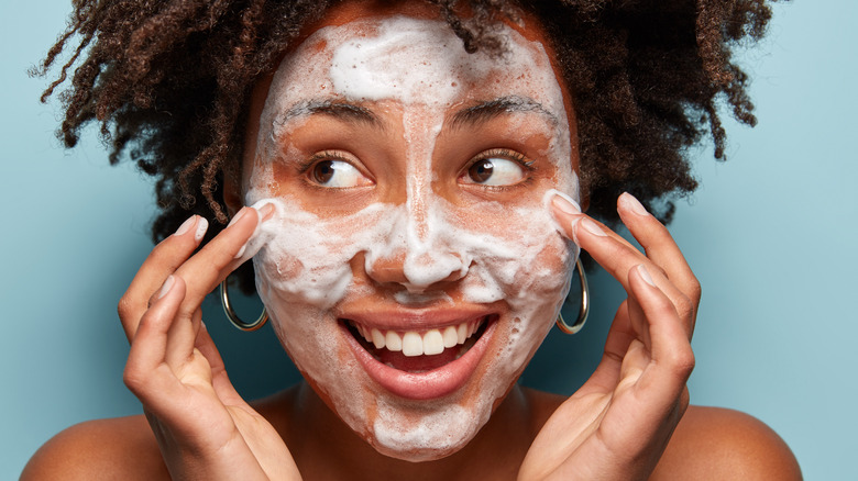 smiling woman with soap on face