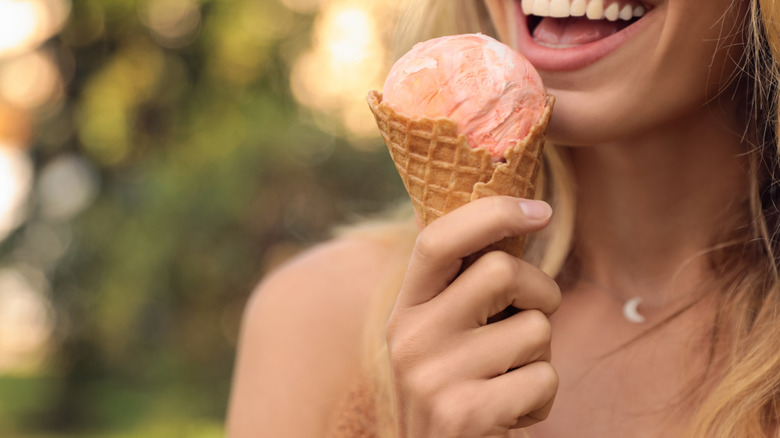 smiling woman eating an ice cream cone