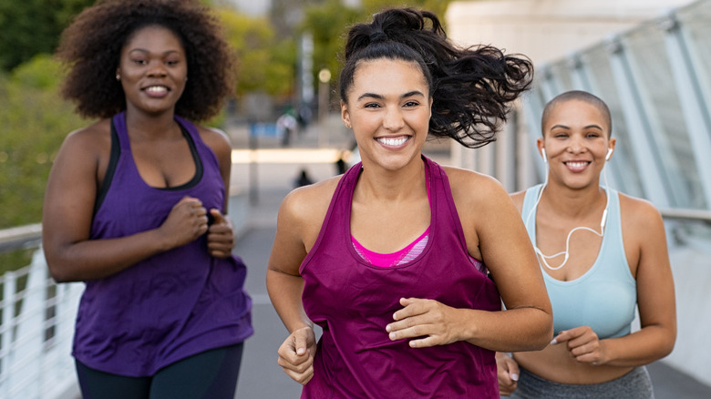 three women smiling and running