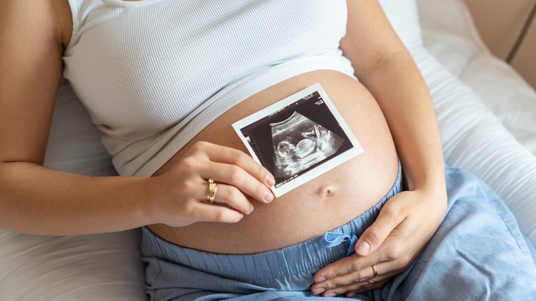 pregnant woman holding ultrasound photo