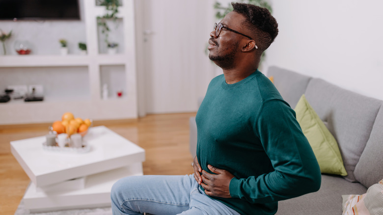 Man holding stomach in pain