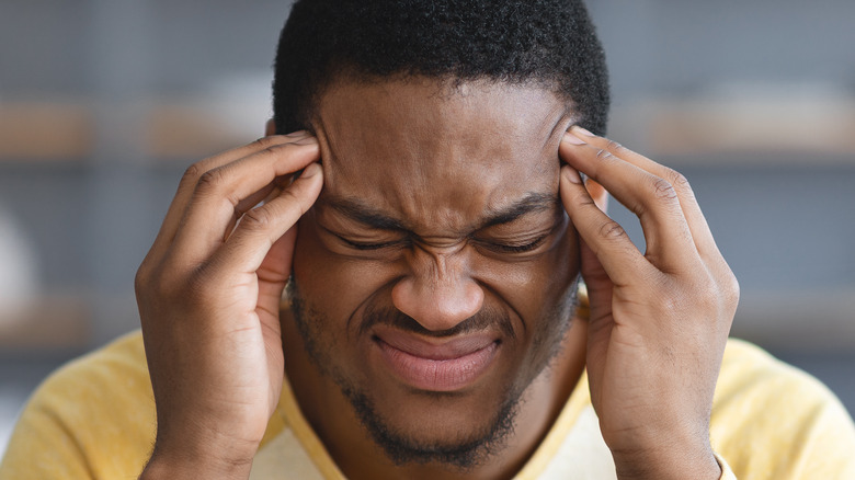 man holding head with pain