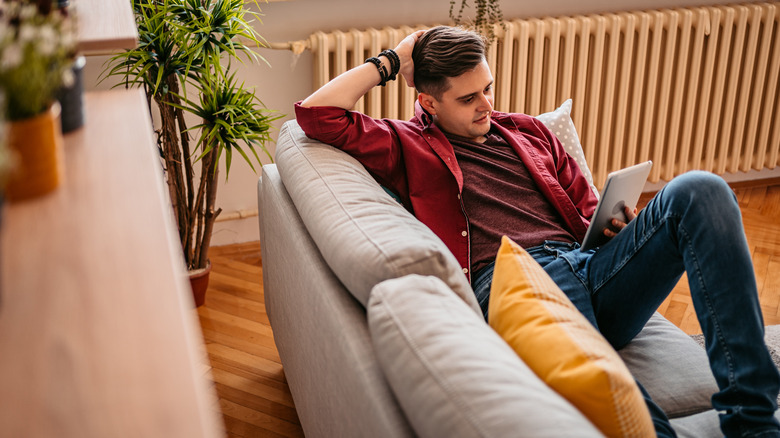 man reading ebook on couch