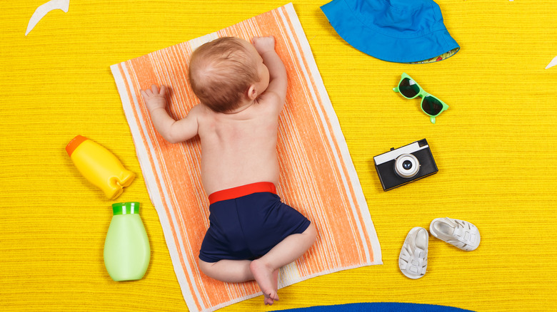 Baby lying on stomach on a yellow beach towel 