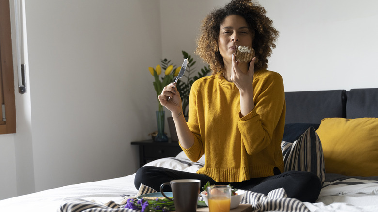 woman eating a snack in bed