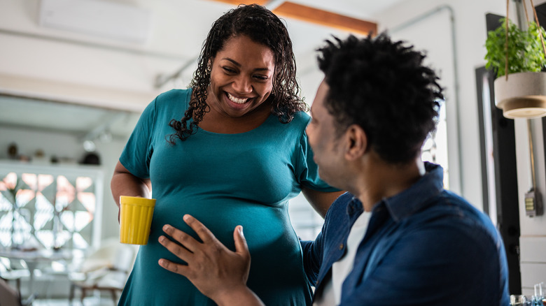 Man touching woman's belly