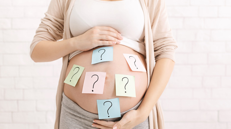 Pregnant woman with question marks