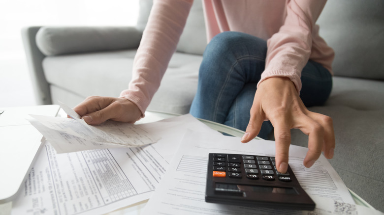 Woman with calculator and bills