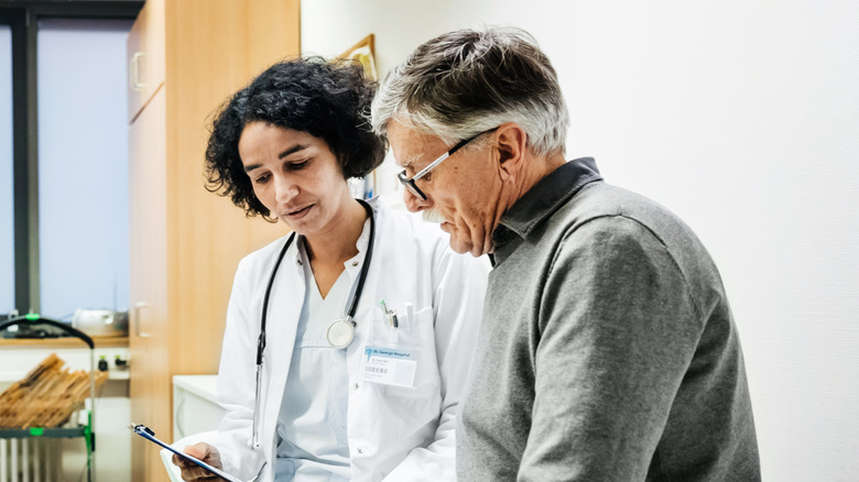 An older adult and his doctor looking at test results