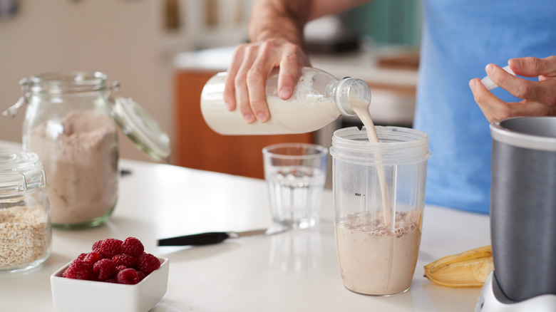 Someone makes a protein shake at home