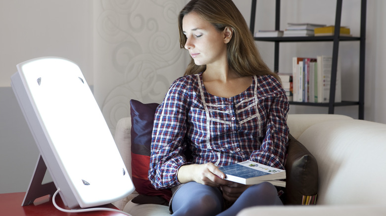 Woman sitting in front of light therapy box