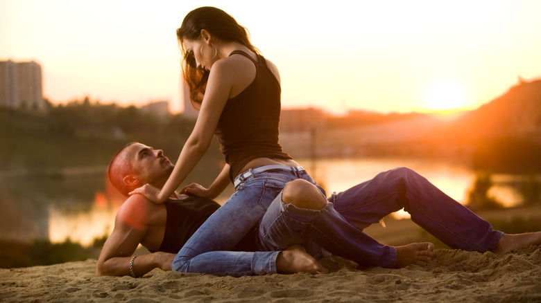 A couple on the beach being intimate together.