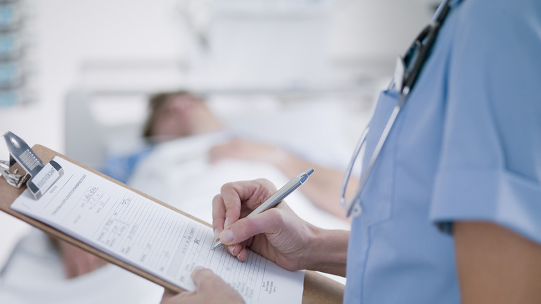 medical clipboard with ICU patient in background