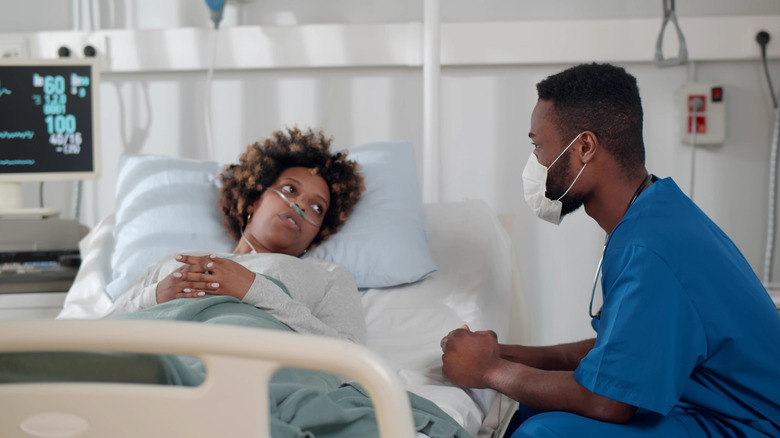 A doctor talking to a patient in a hospital bed