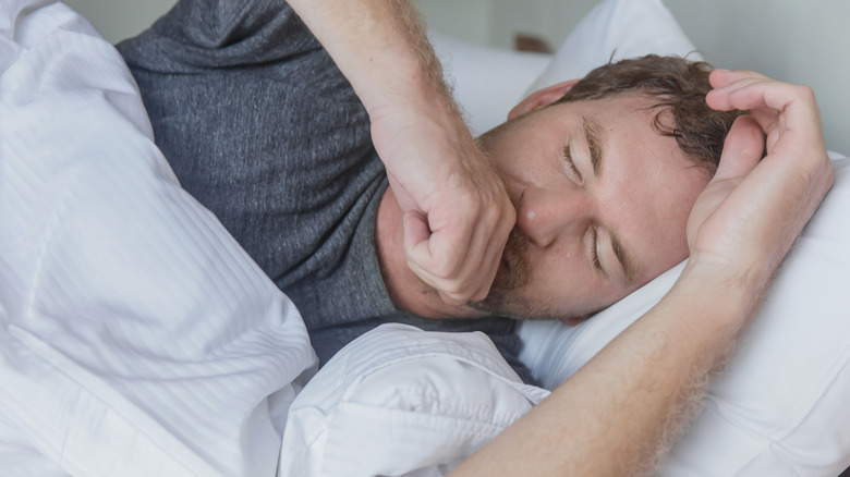 Man coughing in bed