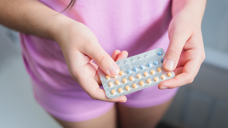 woman holding birth control pills