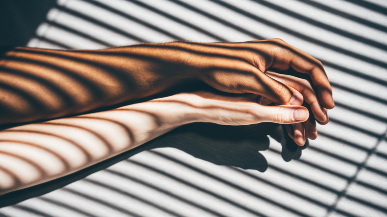 interracial couple holding hands on bed