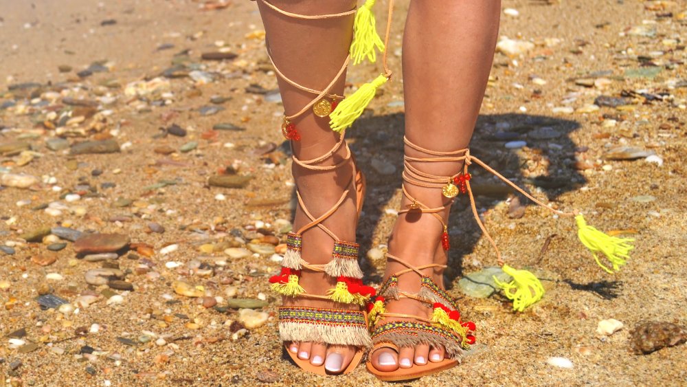 woman wearing gladiator sandals on the beach