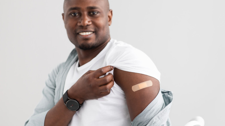 man showed band-aid on arm