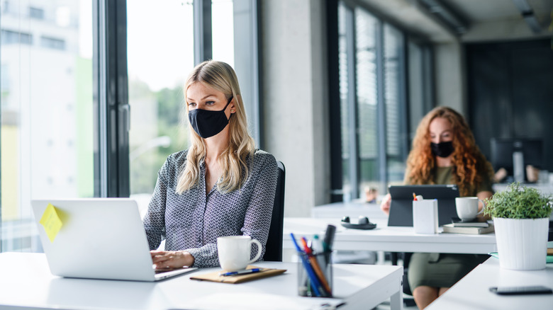 Woman working at computer with face mask on