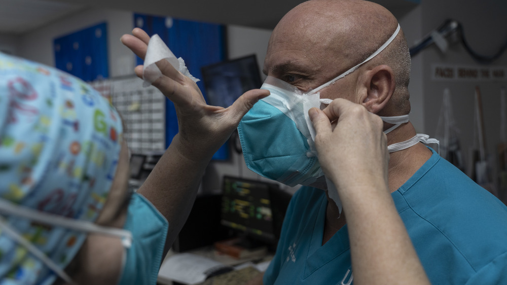 Medical staff tape up gaps in their masks