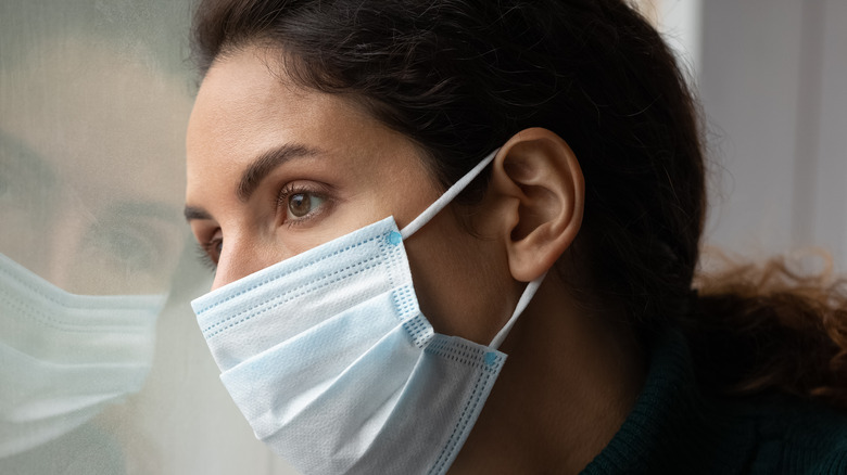 woman at window wearing mask 