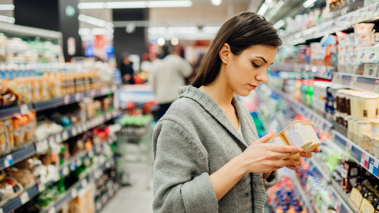 woman checking packaging in grocery store