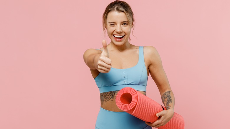 Woman holding yoga mat