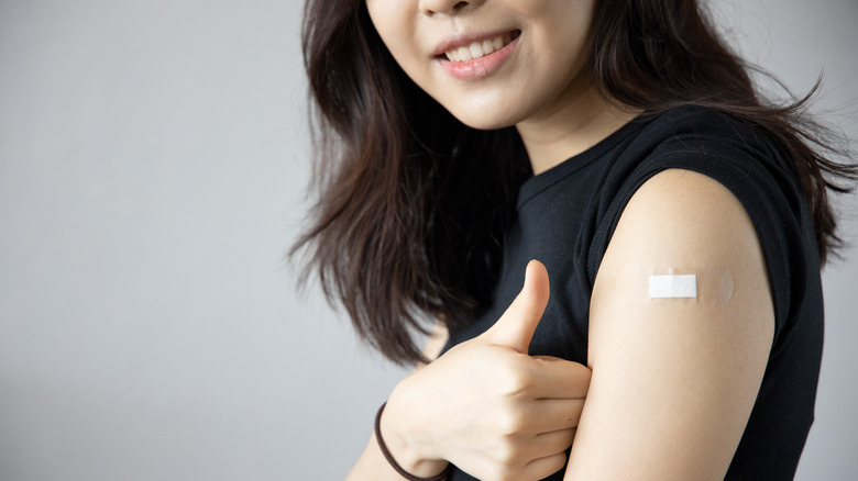 Woman with vaccine bandage on arm 