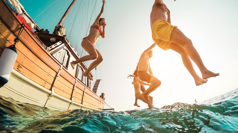 People jumping off boat into water