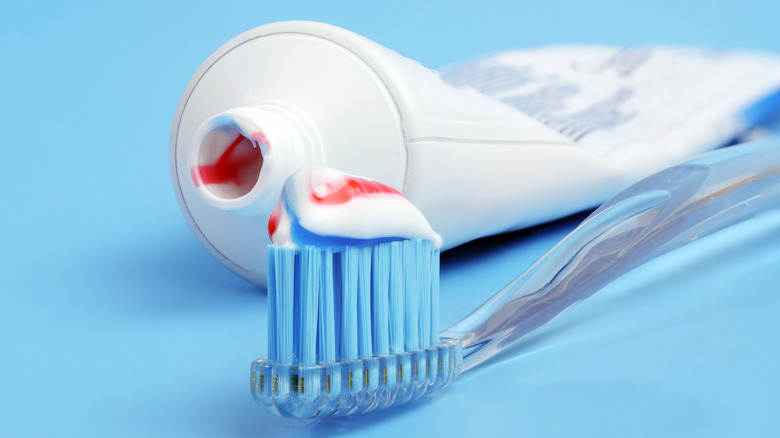 tube of toothpaste next to toothbrush