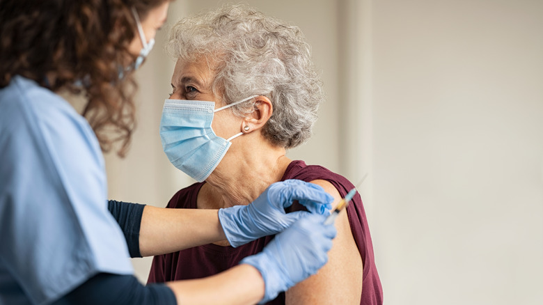 An elderly woman gets a vaccine