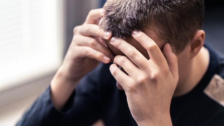 Close up of a man holding his head