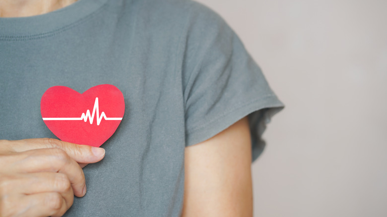 Person holding a heart with an EKG reading