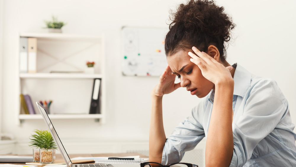 Woman having migraine at desk